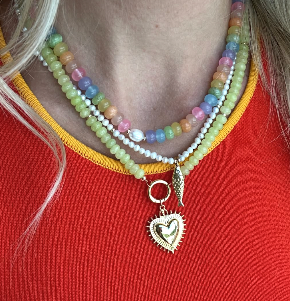 Colorful beaded necklaces layered together on a girl wearing a red top.