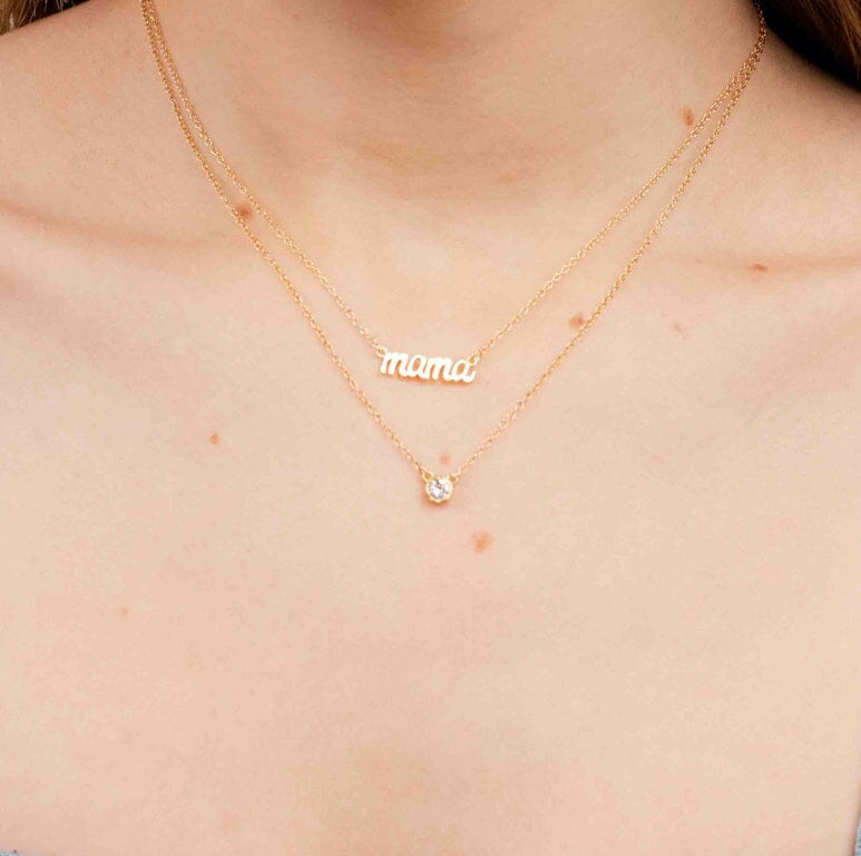 Gold necklace with the word 'Mama' crafted by Katie Dean Jewelry, as displayed on the neck of a woman.