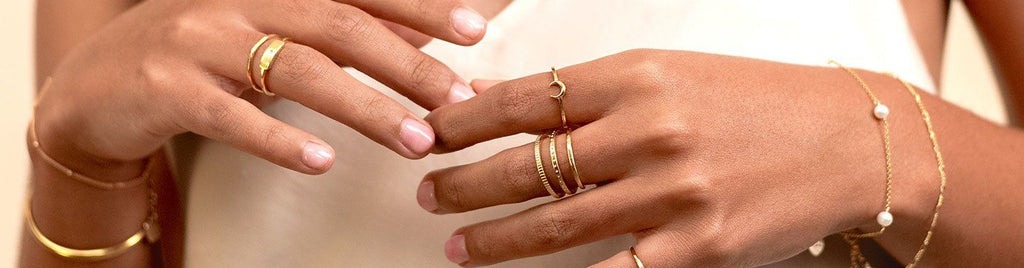 Image showing the hands of a model wearing dainty gold handmade rings by Katie Dean Jewelry