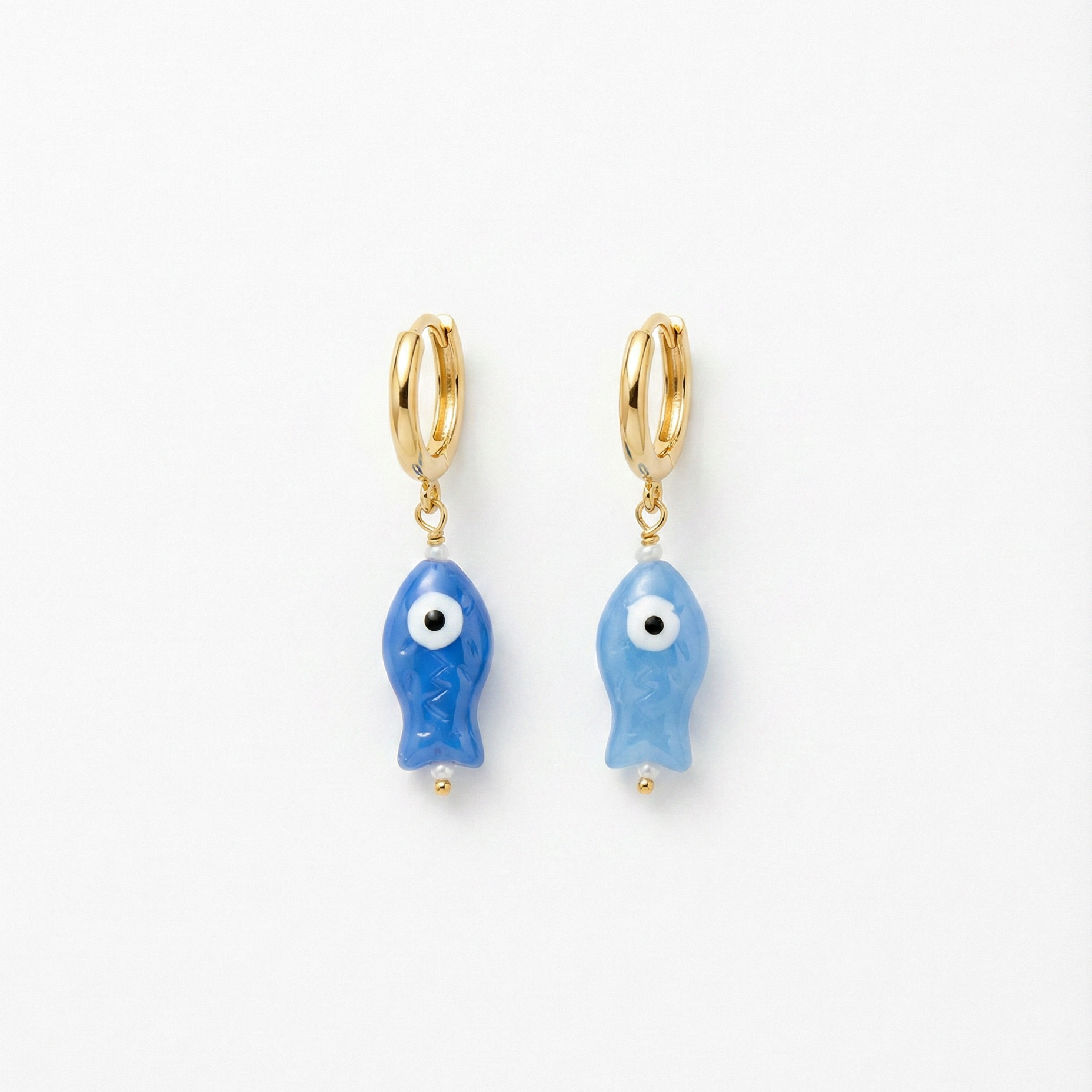 Pair of blue fish-shaped earrings with gold hoops on a white background