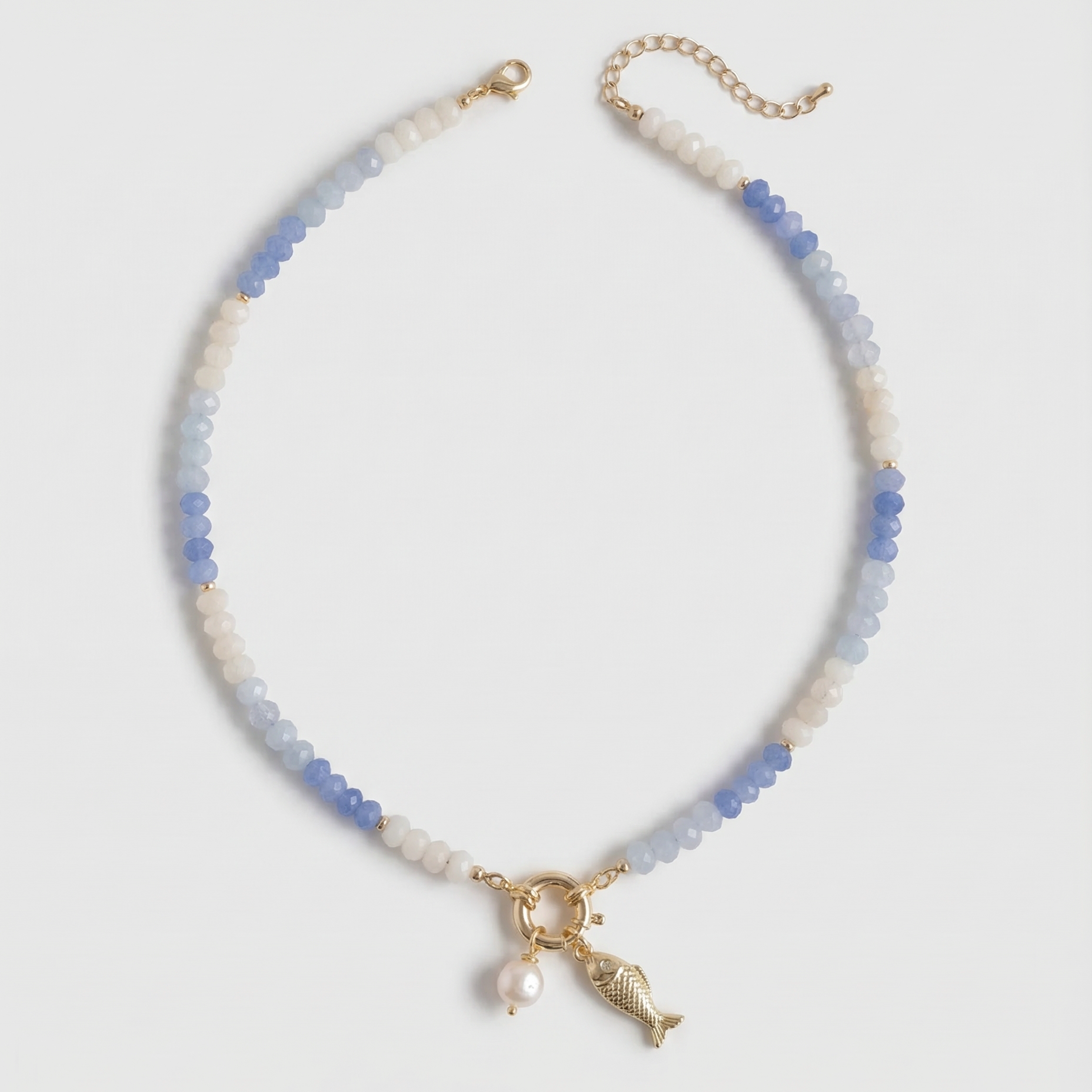 Beaded multi colored necklace with a gold fish charm and pearl charm on a light gray background