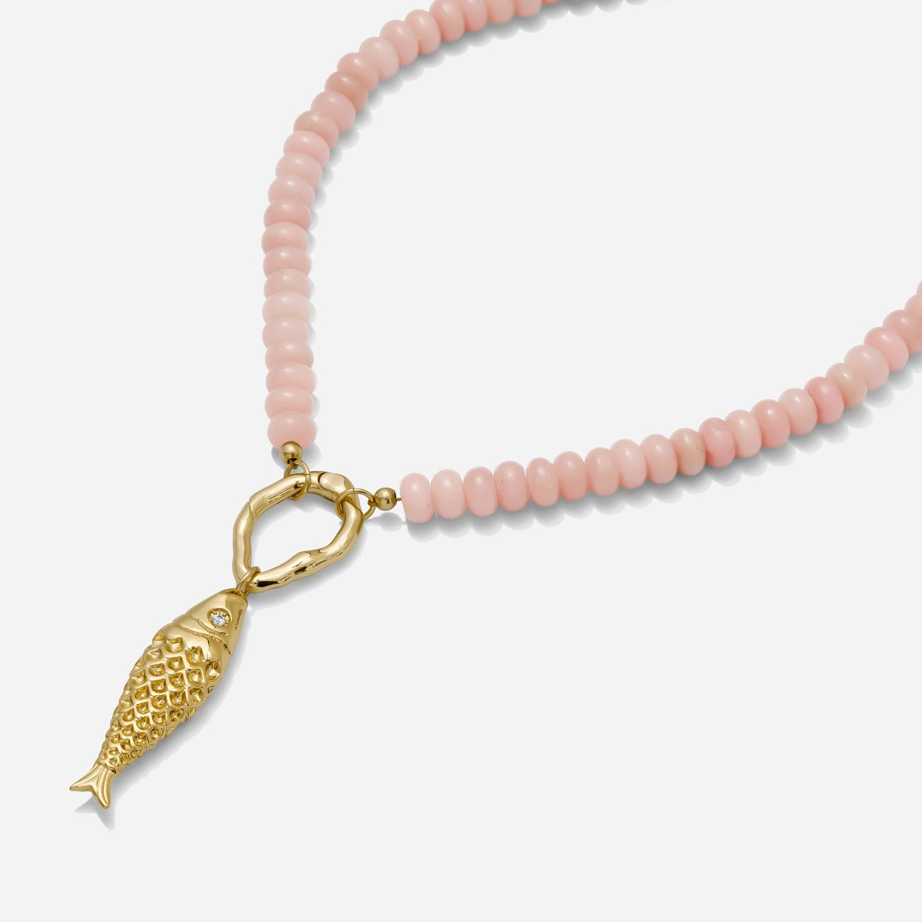 Pink opal beaded necklace with gold fish charm and gold carabiner clasp on a white clasp. Hand beaded by Katie Dean Jewelry.