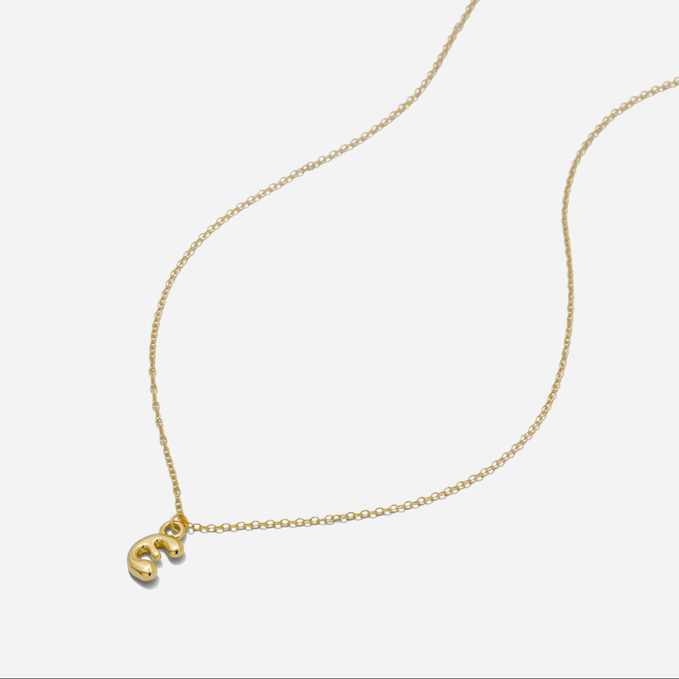 Dainty Gold puffy initial "E" pendant necklace on an 18-inch gold filled chain as seen on a white background.