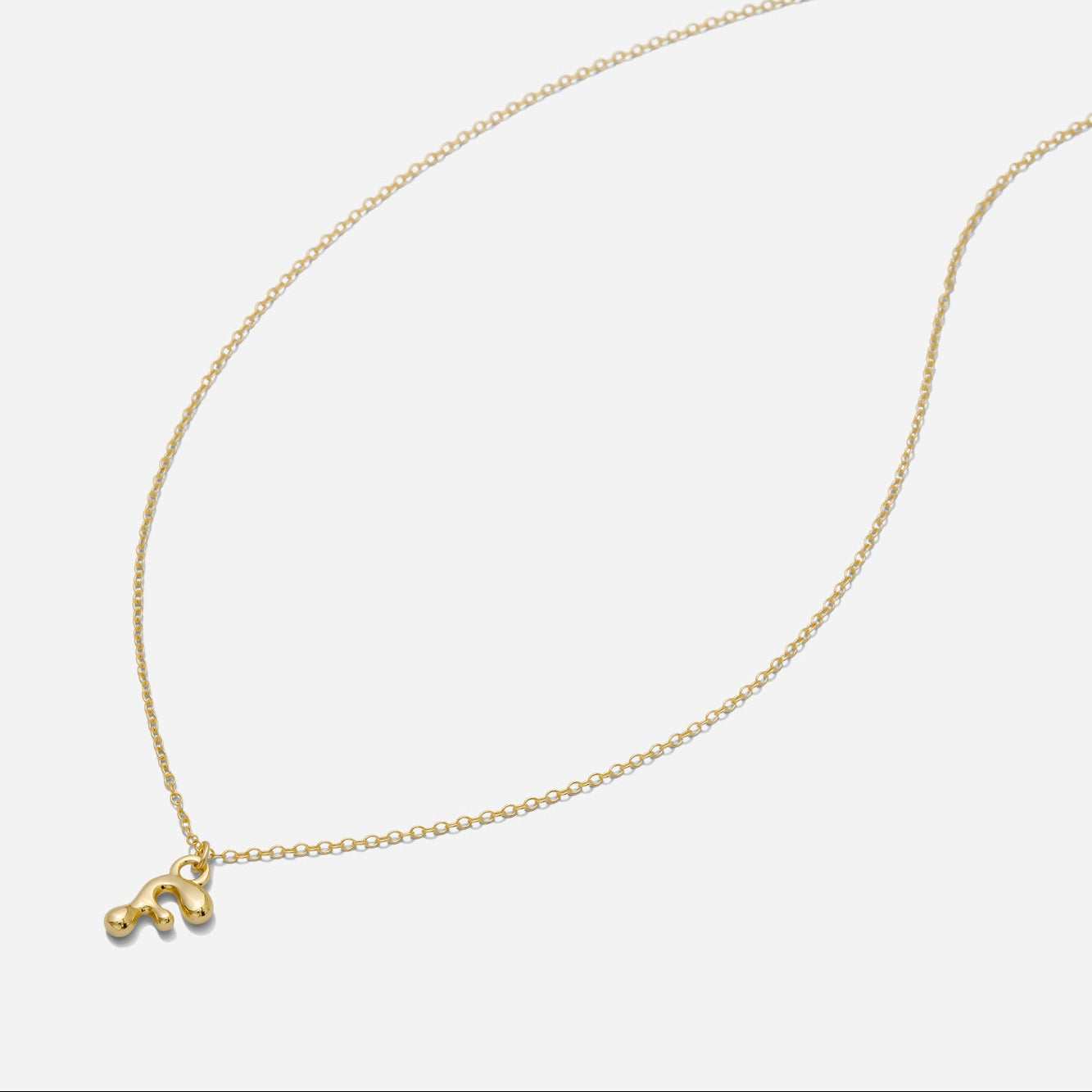 Dainty Gold puffy initial "F" pendant necklace on an 18-inch gold filled chain as seen on a white background.