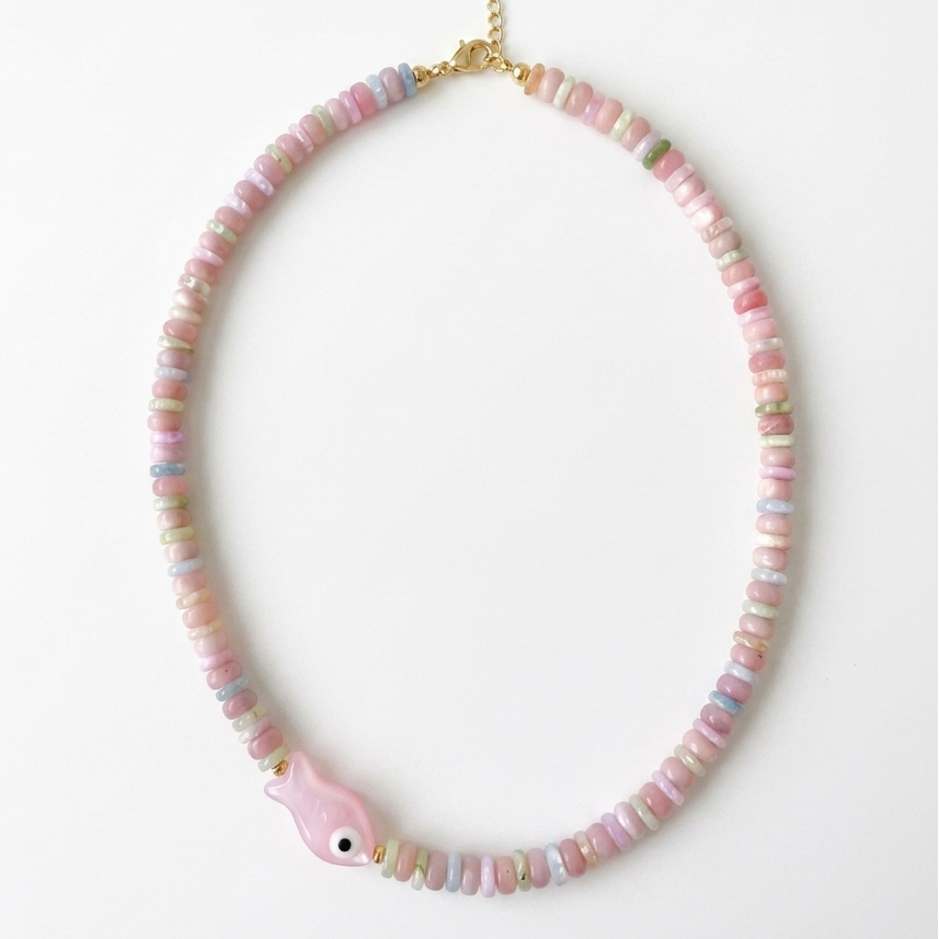 Necklace with pink beads and pink fish on a white background
