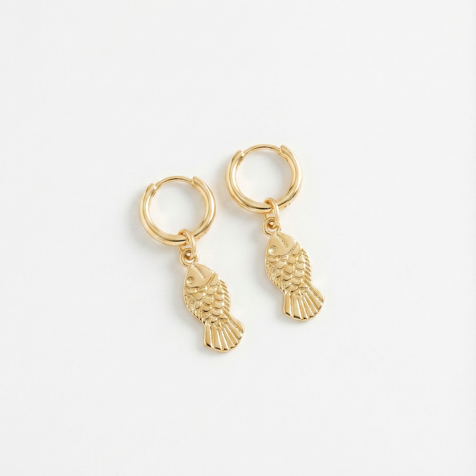 gold hoop earrings with detailed fish charm pendants on white background