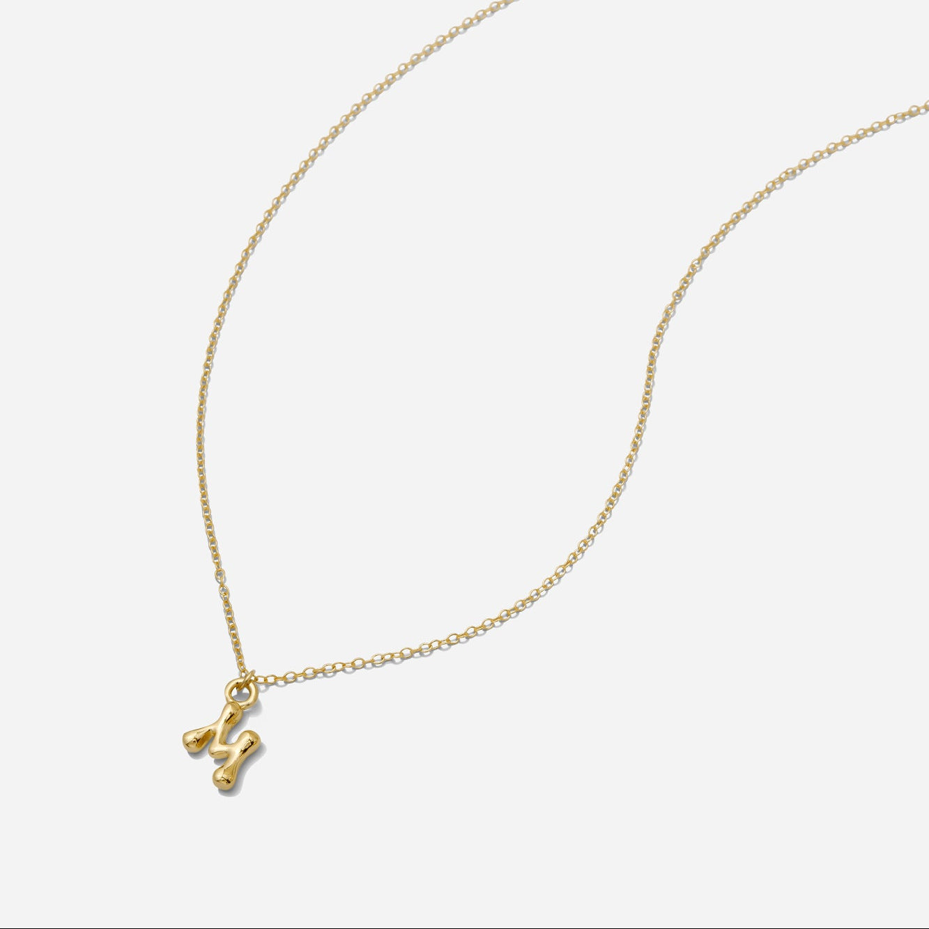 Dainty Gold puffy initial "M" pendant necklace on an 18-inch gold filled chain as seen on a white background.