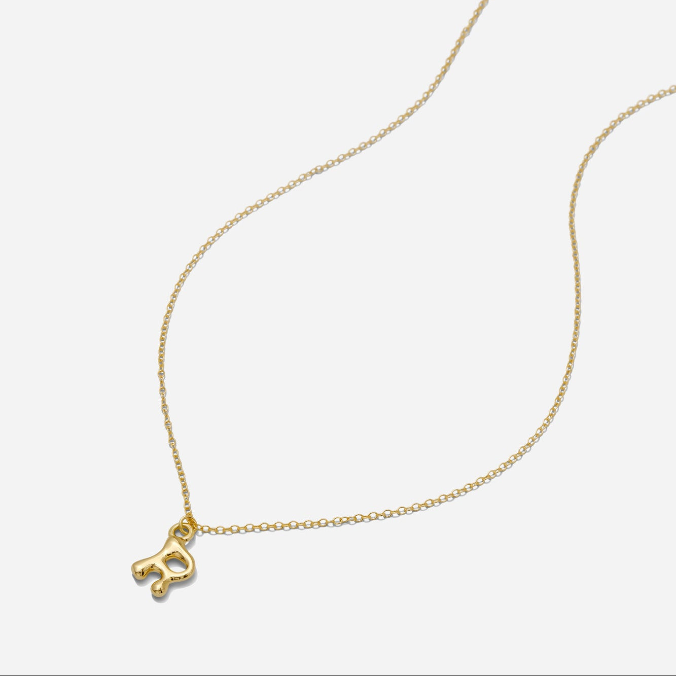 Dainty Gold puffy initial "R" pendant necklace on an 18-inch gold filled chain as seen on a white background.