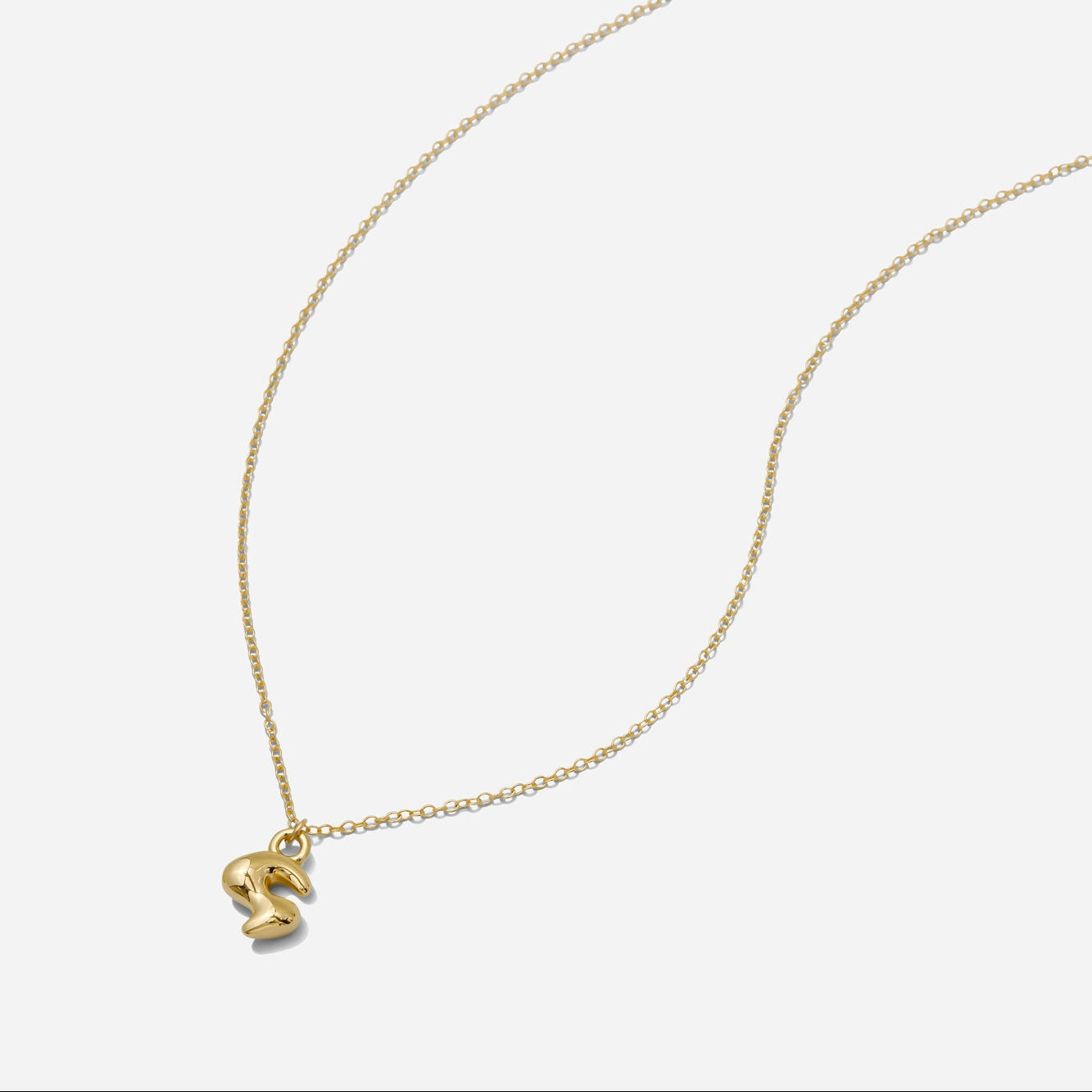Dainty Gold puffy initial "S" pendant necklace on an 18-inch gold filled chain as seen on a white background.