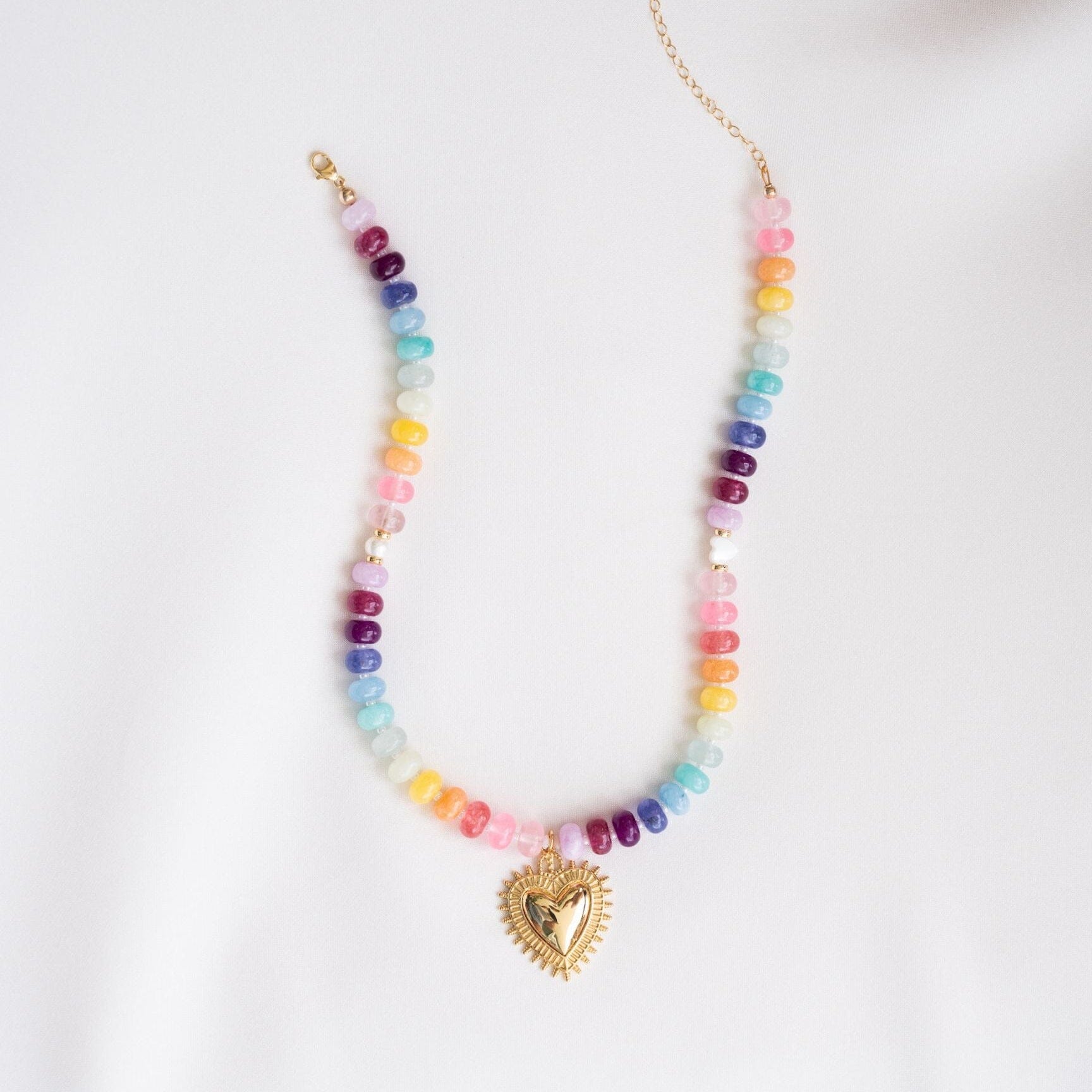 Necklace with colorful beads and a heart-shaped pendant on a white background