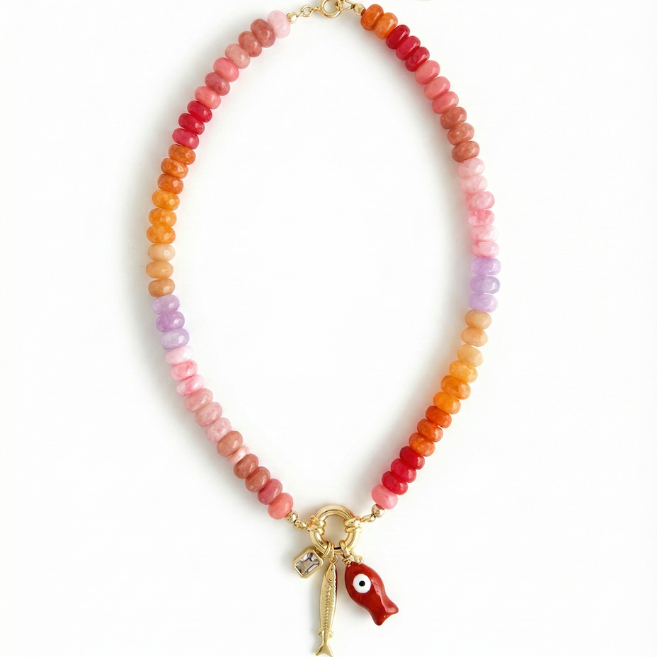Necklace with multicolored beads and a gold fish charm, red fish charm and a white stone charm on a white background