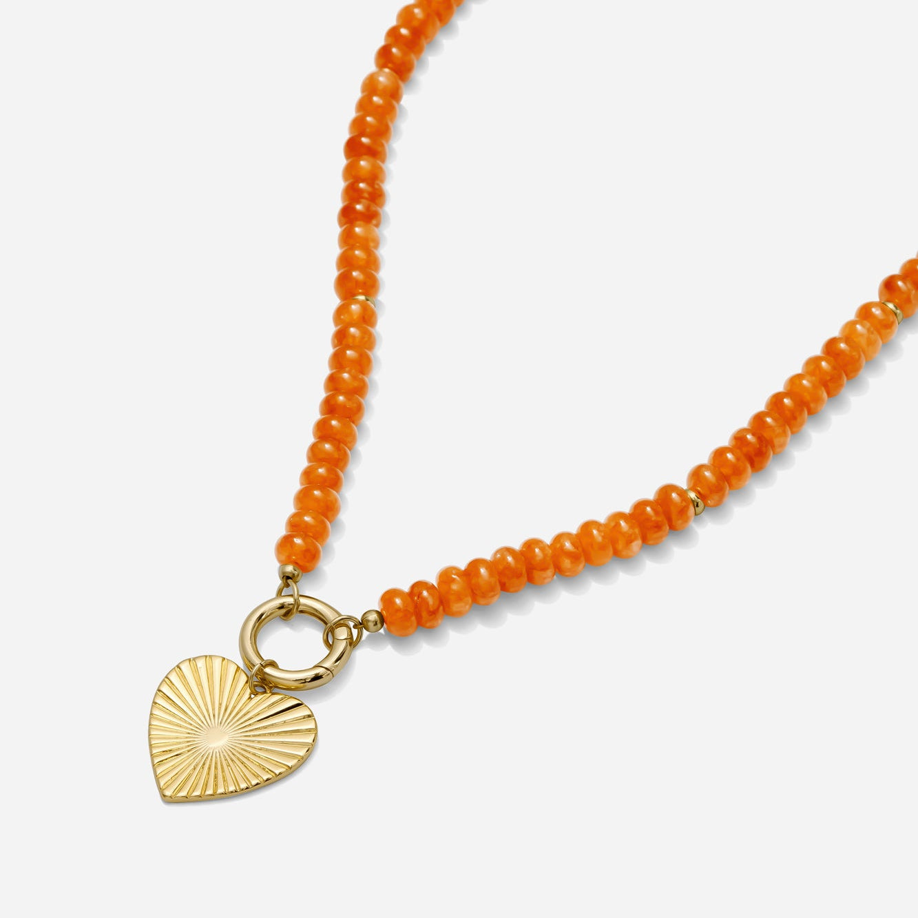 Orange beaded necklace with a gold carabiner clasp and gold heart charm on a white background handmade by Katie Dean Jewelry