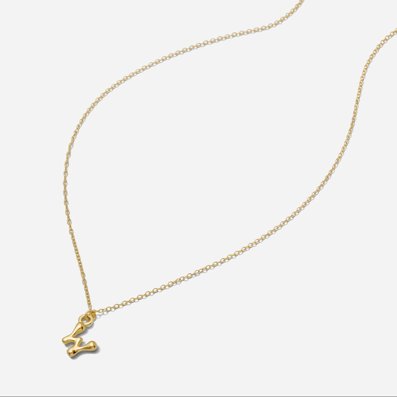 Dainty Gold puffy initial "W" pendant necklace on an 18-inch gold filled chain as seen on a white background.