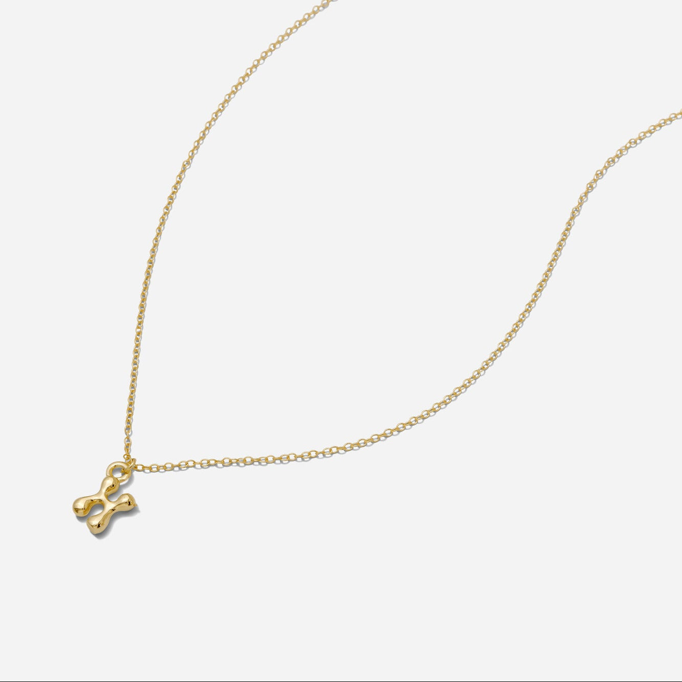 Dainty Gold puffy initial "X" pendant necklace on an 18-inch gold filled chain as seen on a white background.