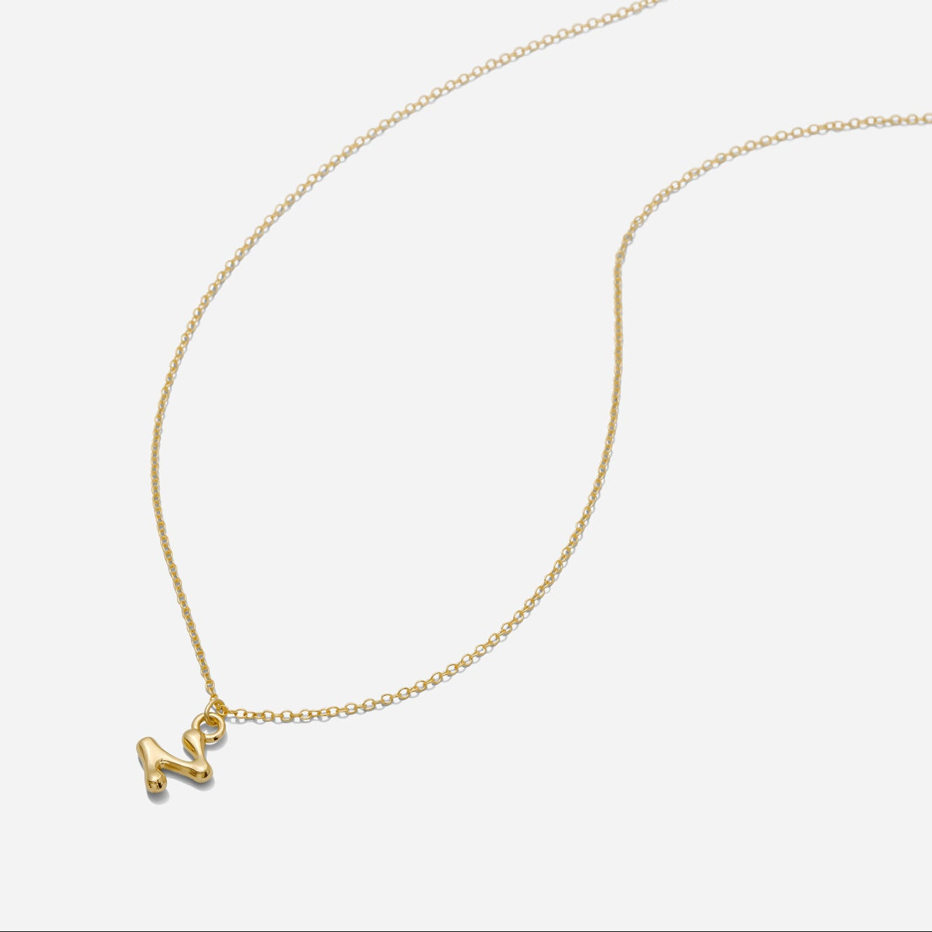 Dainty Gold puffy initial "Z" pendant necklace on an 18-inch gold filled chain as seen on a white background.