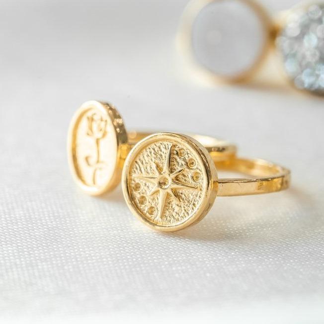 Eight pointed star ring show with other golden jewels made by Katie Dean Jewelry.