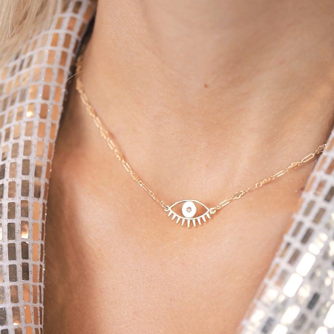 Caucasian model wearing a dainty gold yet minimal Evil Eye Necklace. Handmade in California.