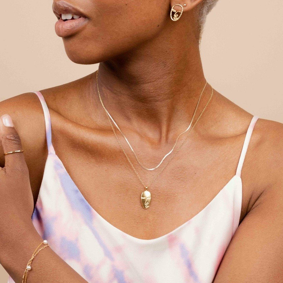 The Herringbone Chain shining brightly layered with the Artist Face Necklace, handmade by Katie Dean Jewelry