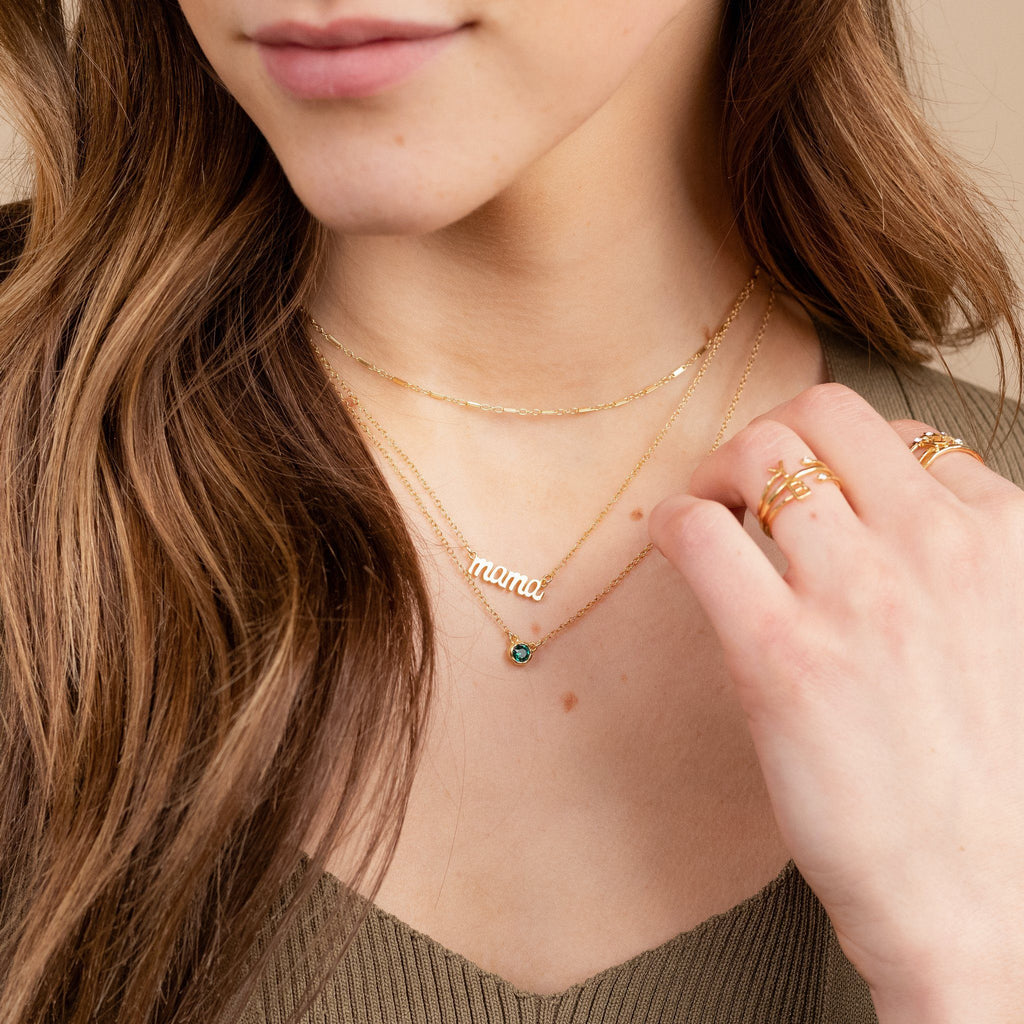 Dainty gold Mama Necklace layered with the Link Choker, and May Birthstone Necklace by Katie Dean Jewelry