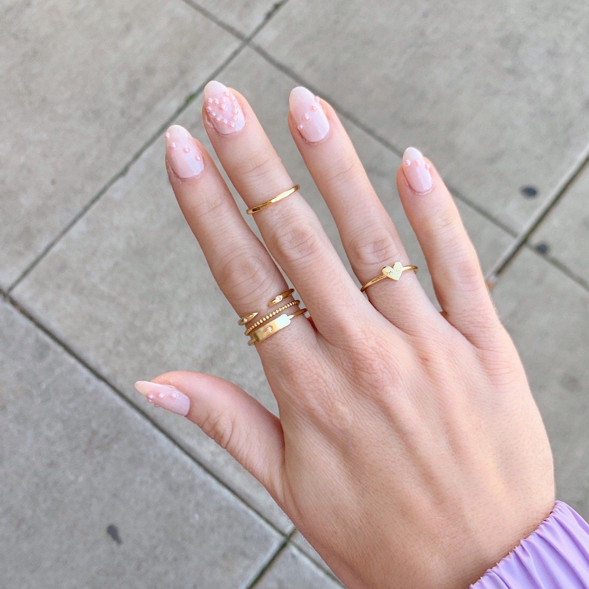 The Rectangle Stack on a hand model showing the Claw Ring, Beaded Ring and Rectangle Ring, handmade in America by Katie Dean Jewelry.