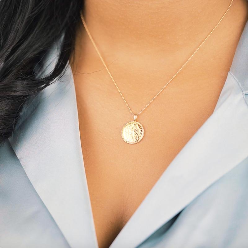 The Beaded Coin Necklace. The beaded edging and hammered finish on this coin charm makes it glisten beautifully in the light. It also layers perfectly with the Beaded Arch Necklace. Handmade in California by Katie Dean Jewelry.