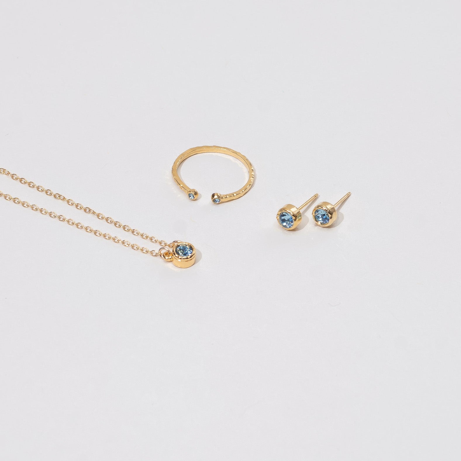 March aquamarine Birthstone Collection including a dainty gold March Birthstone Necklace, Ring and Earrings. Minimal layering jewelry handmade in America by Katie Dean Jewelry.