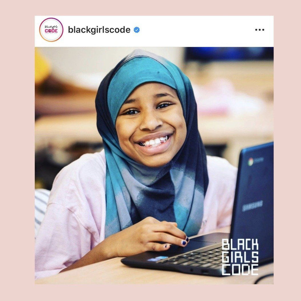 Photo of girl at a computer smiling from Black Girls Code Instagarm