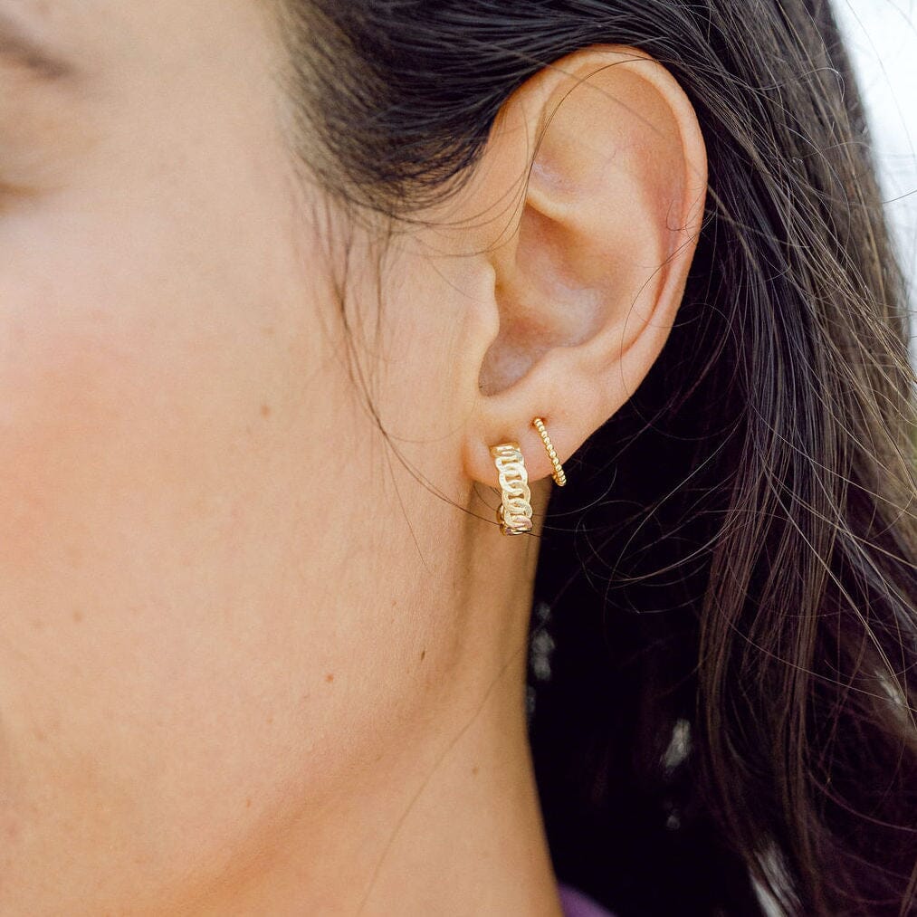 Ear stack featuring the dainty gold, nickel-free Beaded Hoop Studs with complementary earrings from Katie Dean Jewelry, highlighting the possibility for layering and personal style.
