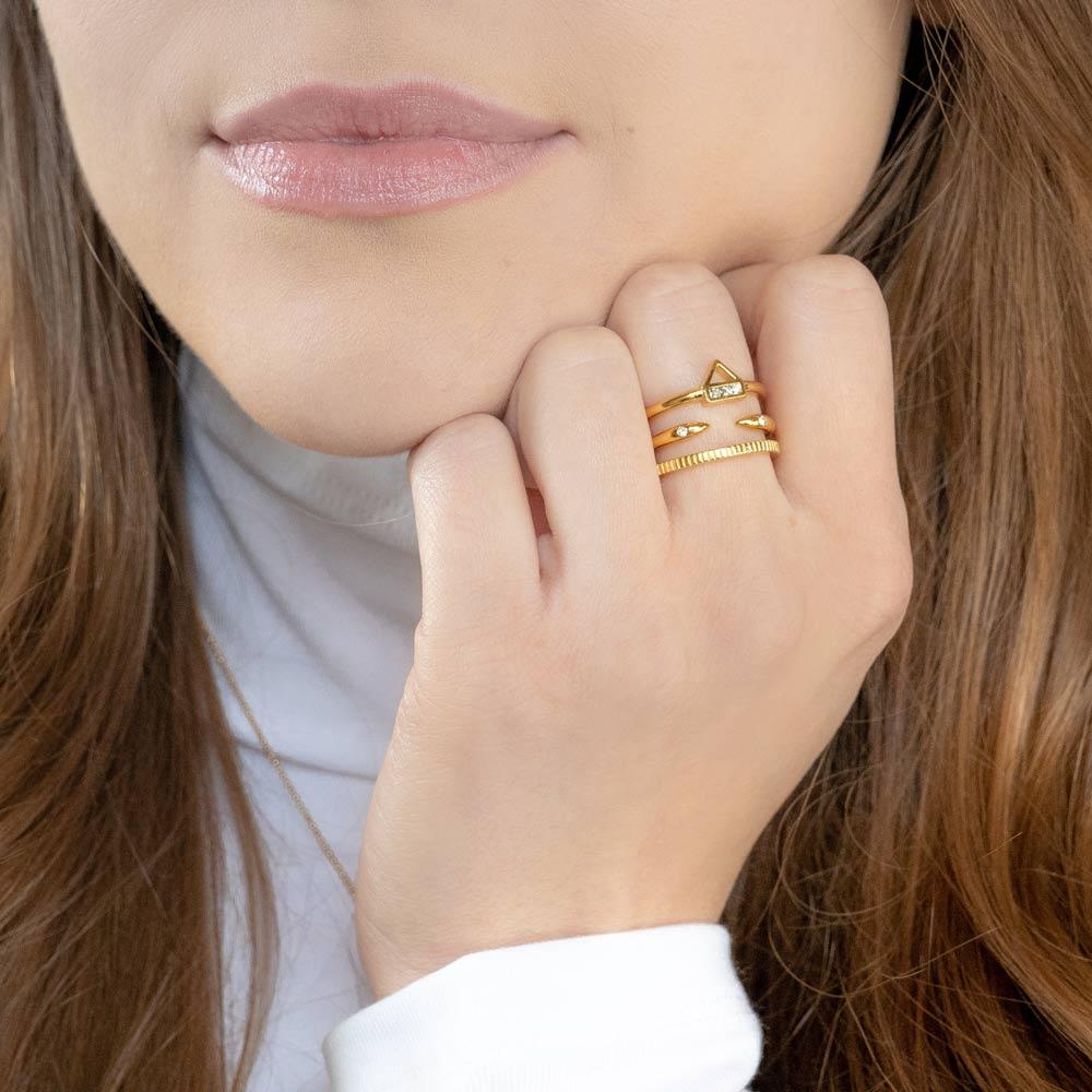 A Katie Dean Model with rich brown hair wearing the Love Triangle, Claw Ring and Coin Ring.