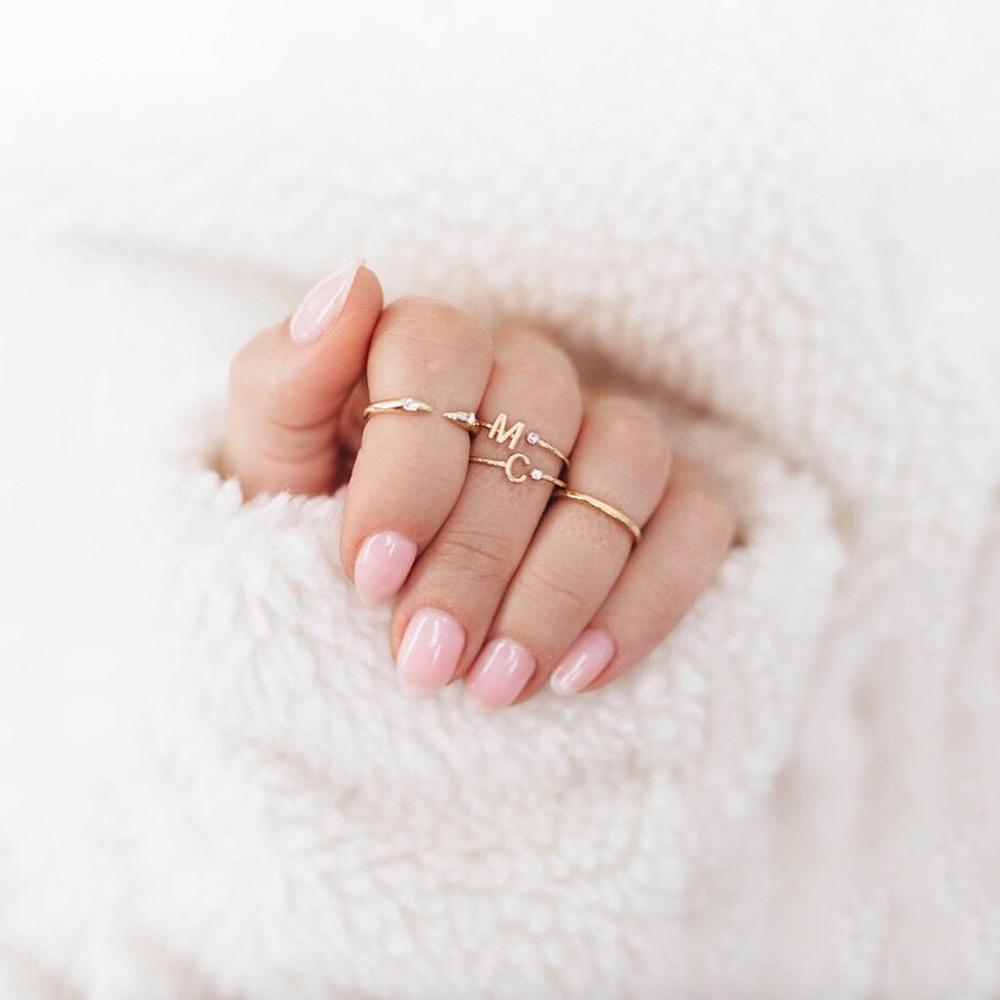 Katie Dean's hand with rings on 3 fingers wrapped in soft white fur.