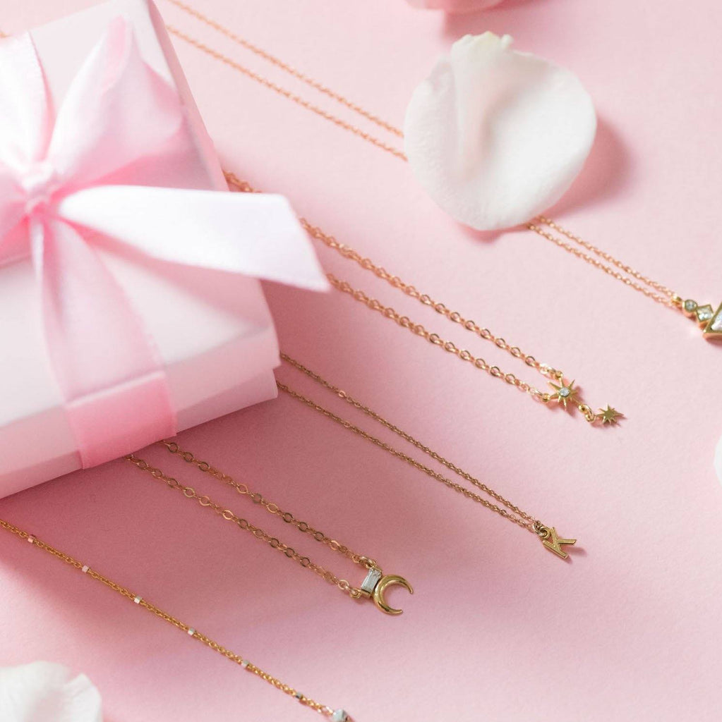 Katie Dean Jewelry on pink flat lay with pink box with pink bow.