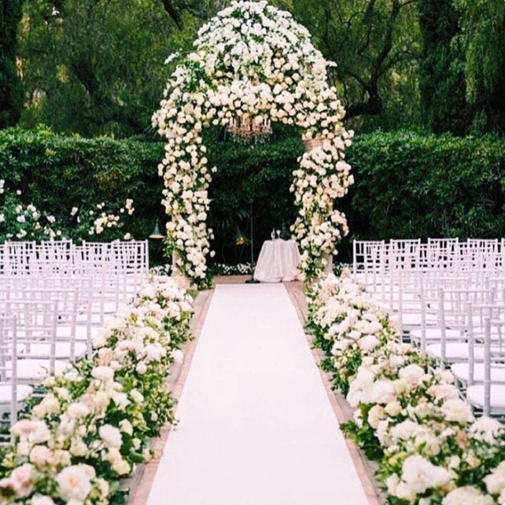 Wedding isle with a white center isle and each side flanked by white and green floral arrangmenets.