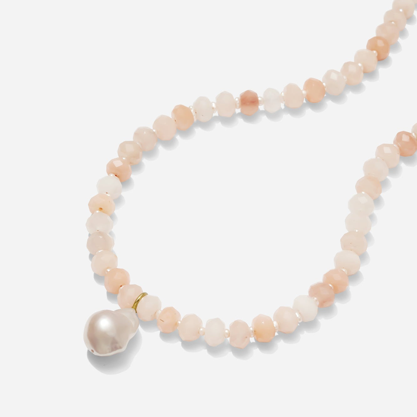 Pink aventurine necklace with baroque pearl pendant on a white background.