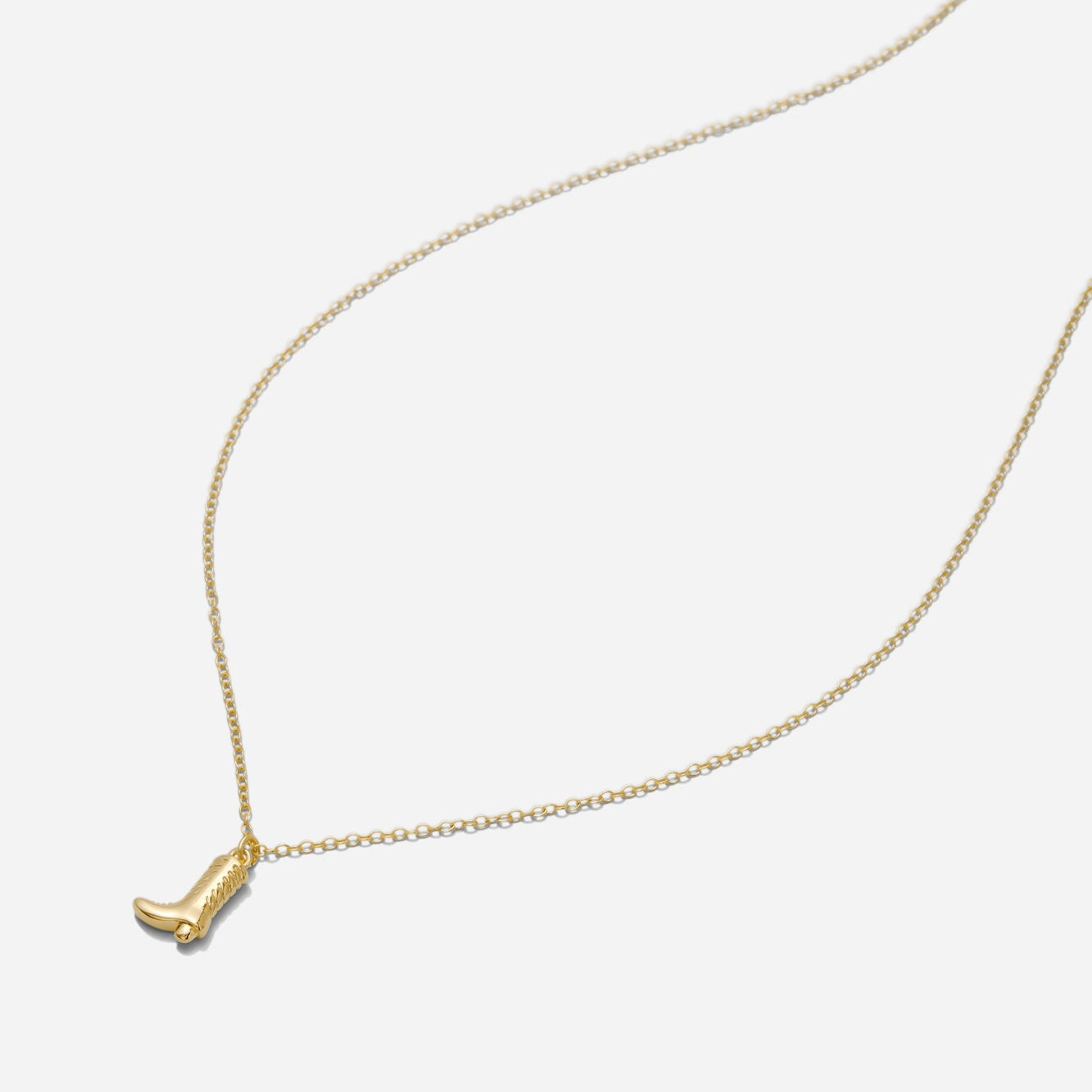 Gold cowgirl boot pendant necklace on an 18-inch gold filled chain shown on an off white background.