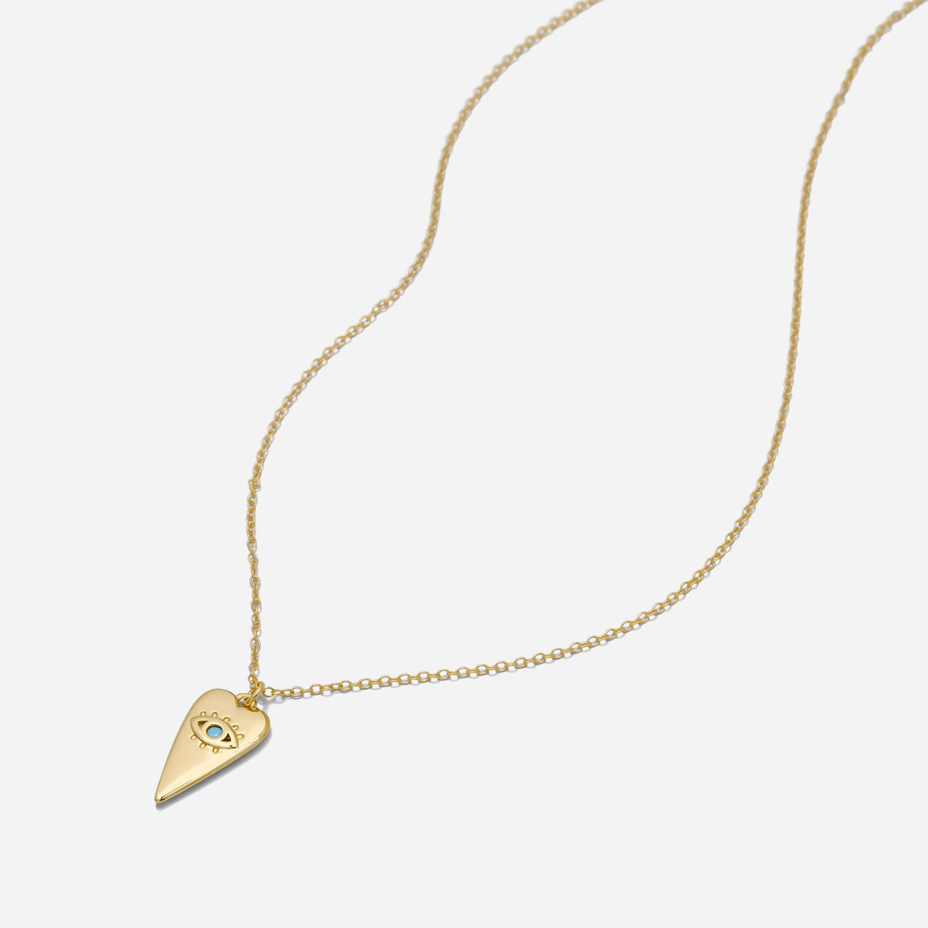 Gold necklace with an elongated heart pendant necklace with evil eye detail on an 18-inch gold filled chain on a white background, made by Katie Dean Jewelry.