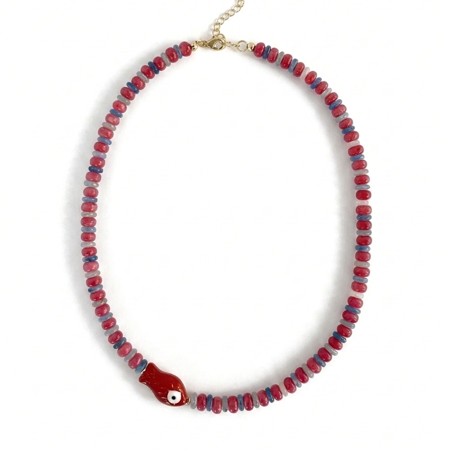 Red and blue beaded necklace with red fish charm on a white background