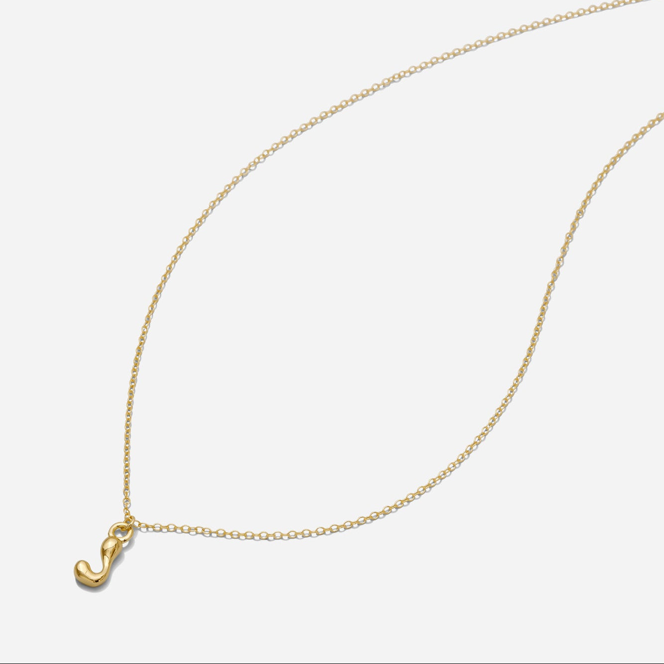 Dainty Gold puffy initial "J" pendant necklace on an 18-inch gold filled chain as seen on a white background.