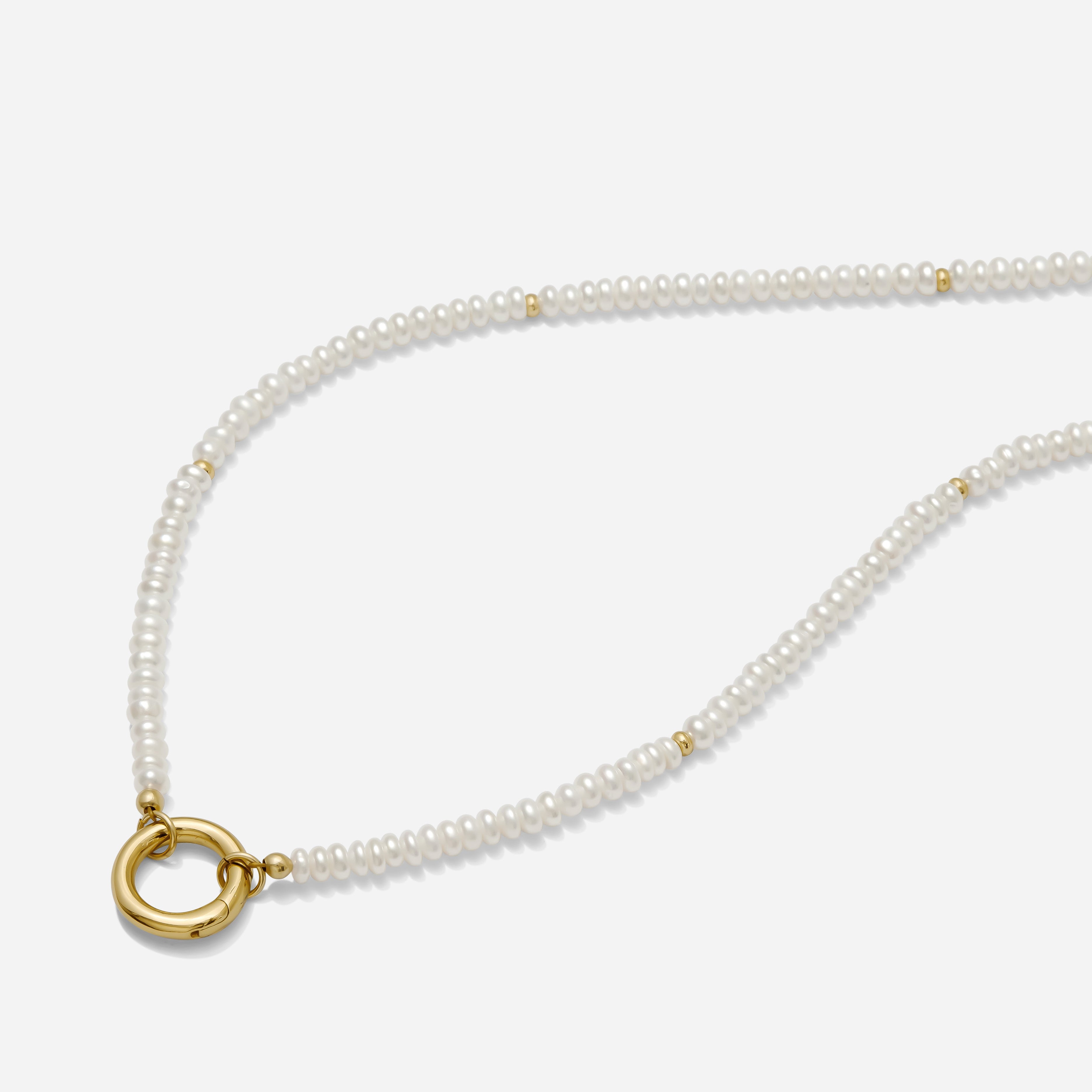 Pearl necklace with a gold circle pendant on a white background handmade by Katie Dean Jewelry.