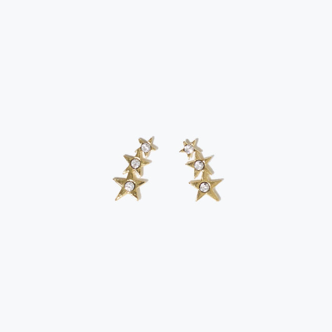 Image of the dainty gold Starburst Ear Crawler stud earrings with white Swarovski crystals on a natural white background.