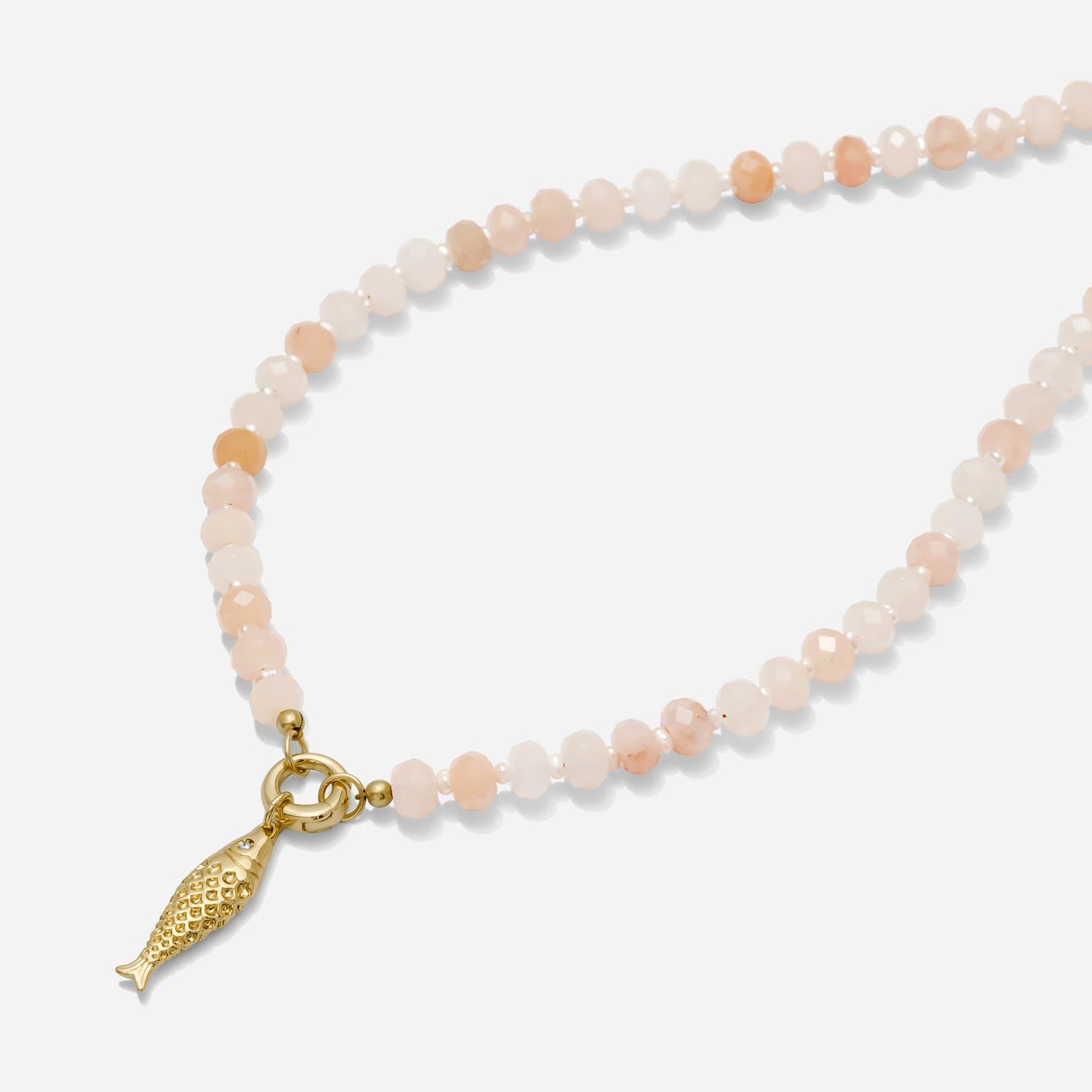 Necklace with pink aventurine beads and a gold fish charm on a white background handmade by Katie Dean Jewelry.