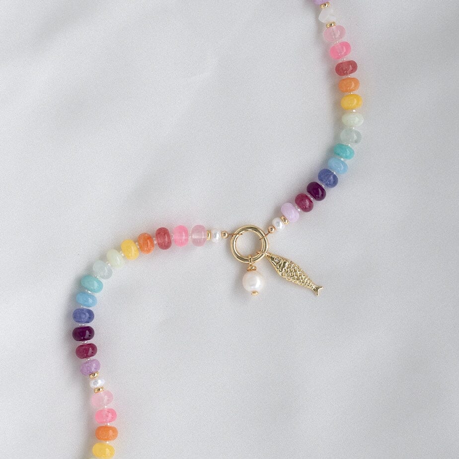 Multicolored beaded necklace with a gold charm on a white background