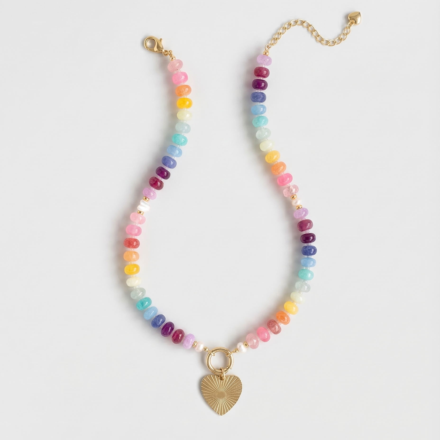 Multicolored beaded necklace with a gold heart charm on a white background