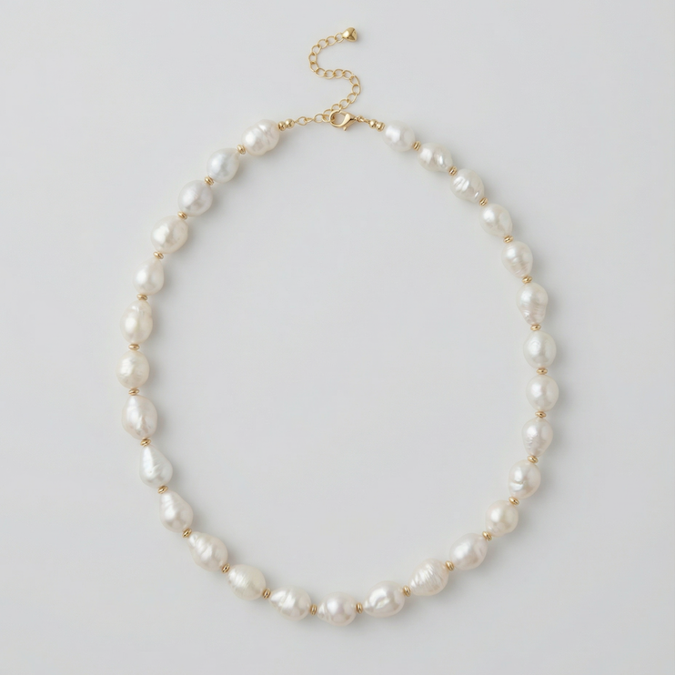 Pearl necklace with gold clasp on a light gray background