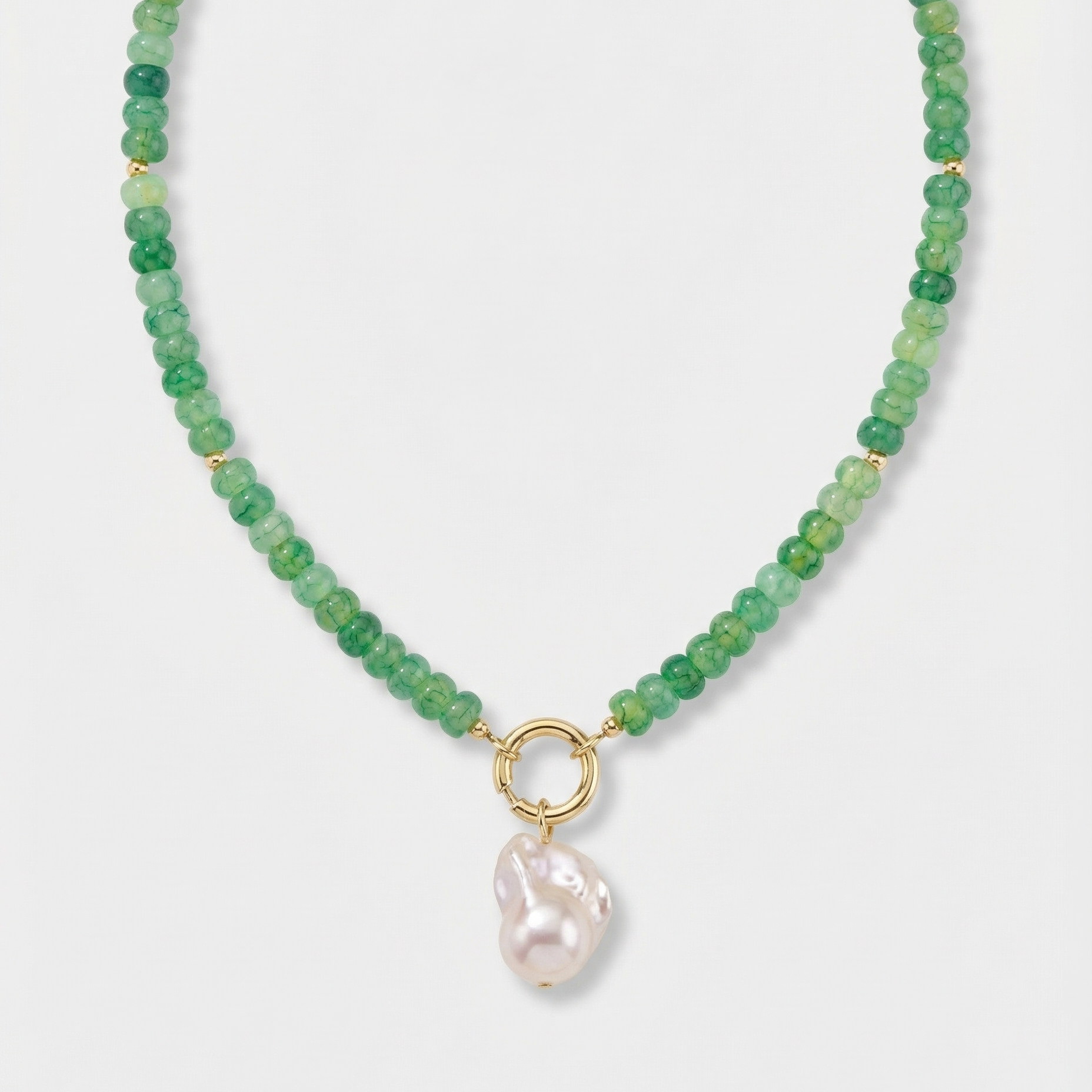 Green beaded necklace with large pearl charm on a white background.