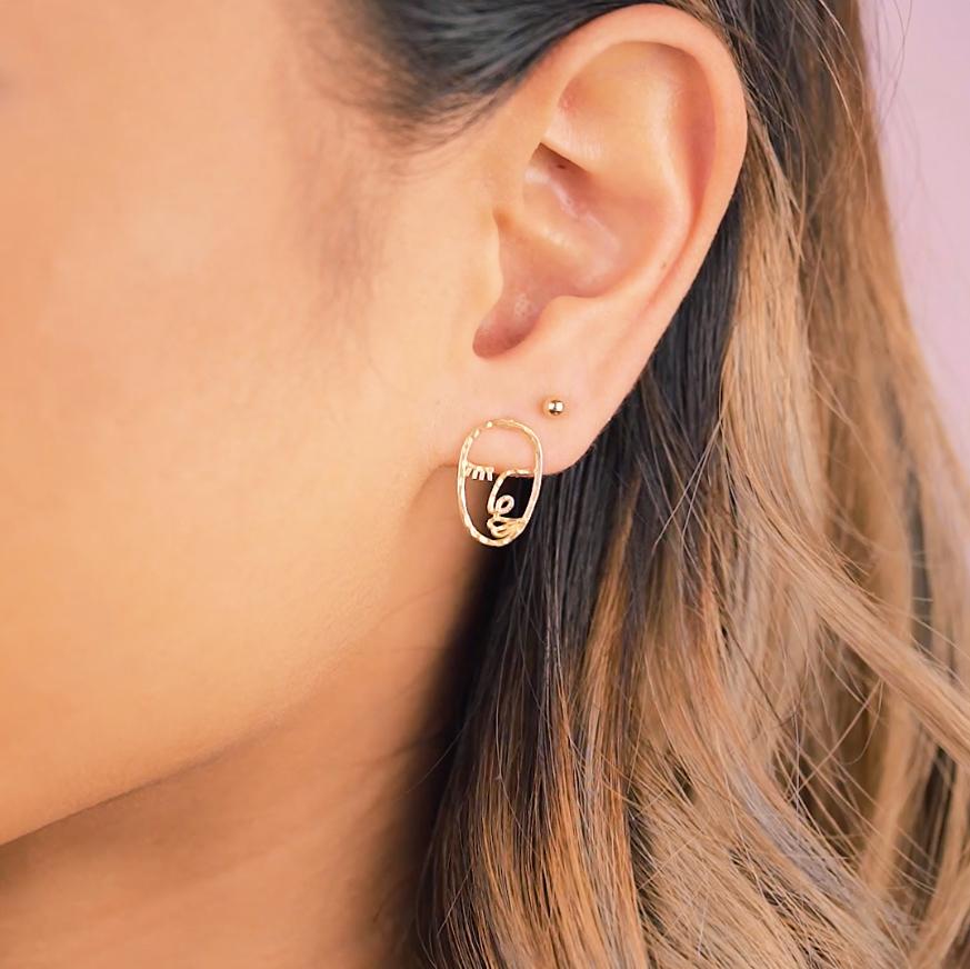 Model wearing the Beaded gold stud earring and the Artist Face Earring inspired by Matisse and Picasso. Handmade in California by Katie Dean Jewelry.