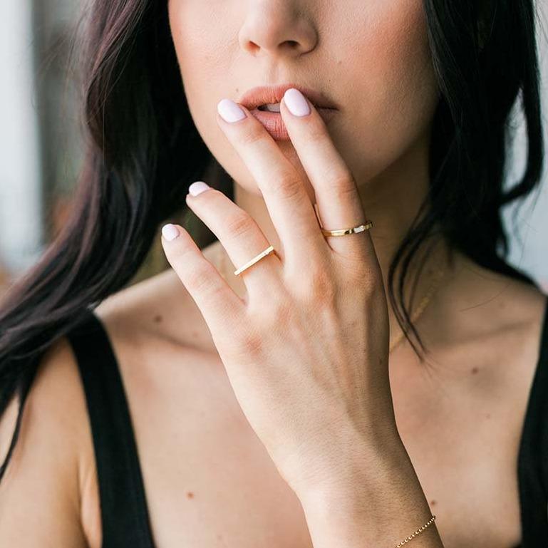 Model wearing the gold Baguette and Bar with Gem ring, made by Katie Dean Jewelry
