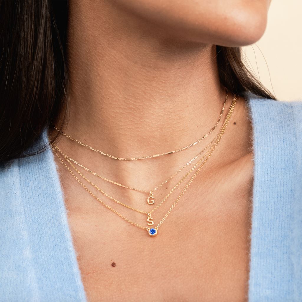 Model wearing the September sapphire Birthstone Necklace and Initial G & S Necklaces, as well as the Linked Choker Necklace, minimal layering necklaces handmade in America by Katie Dean Jewelry