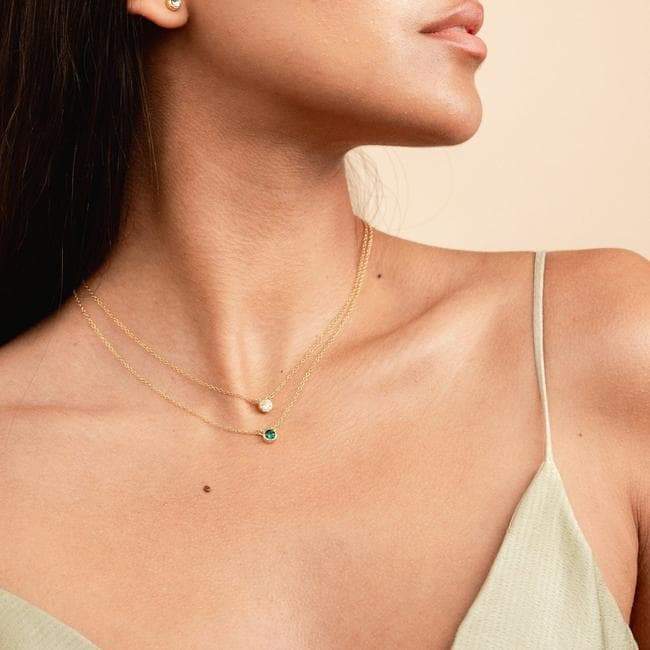 Model wearing the April crystal Birthstone Necklace and May emerald Birthstone Necklace, minimal layering necklaces handmade in America by Katie Dean Jewelry