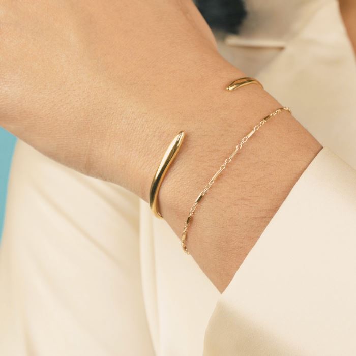 Hand model wearing the gold Claw Cuff and Linked Bracelet, made by Katie Dean Jewelry.