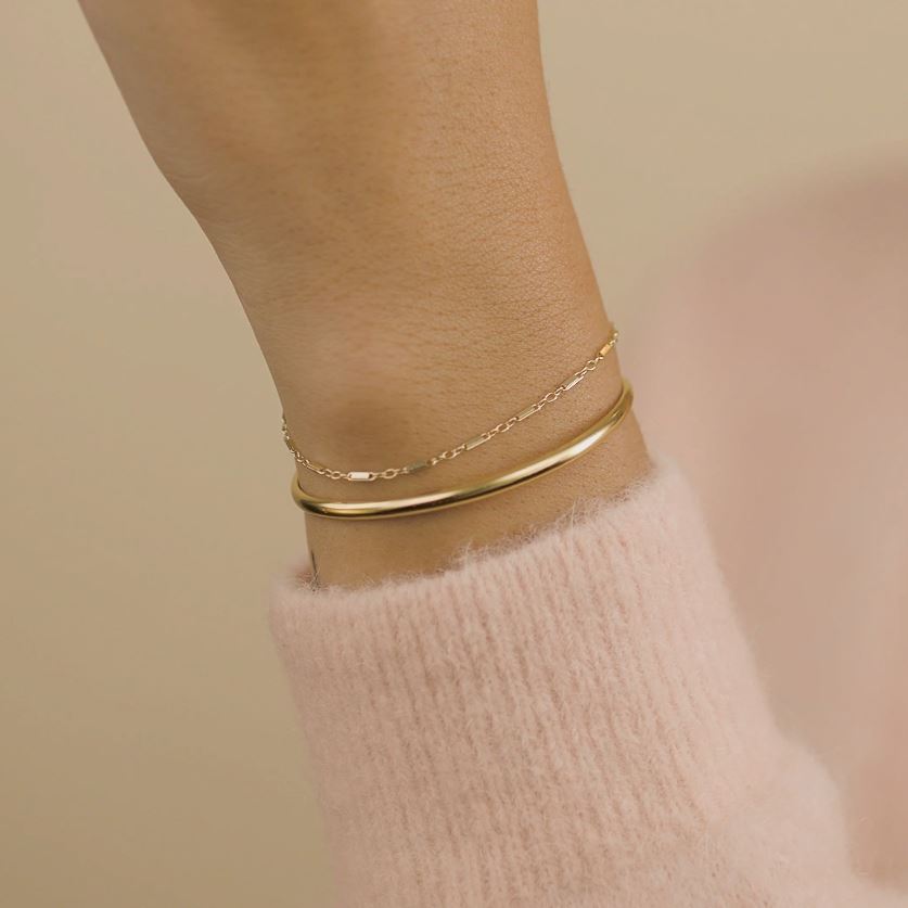 Hand model wearing the gold Claw Cuff and Linked Bracelet, made by Katie Dean Jewelry.